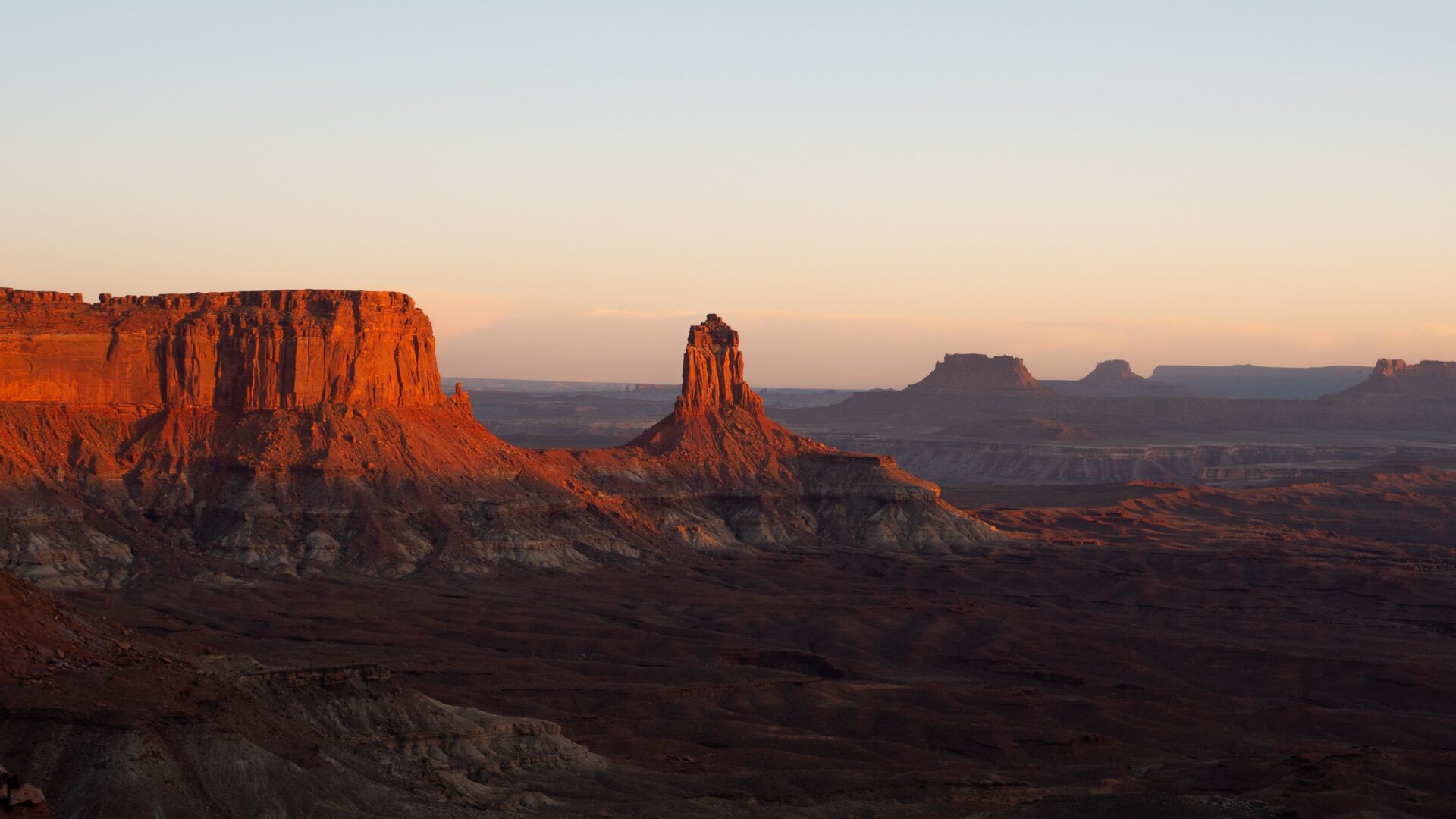 View of the sun setting over red rock in Canyonlands National Park