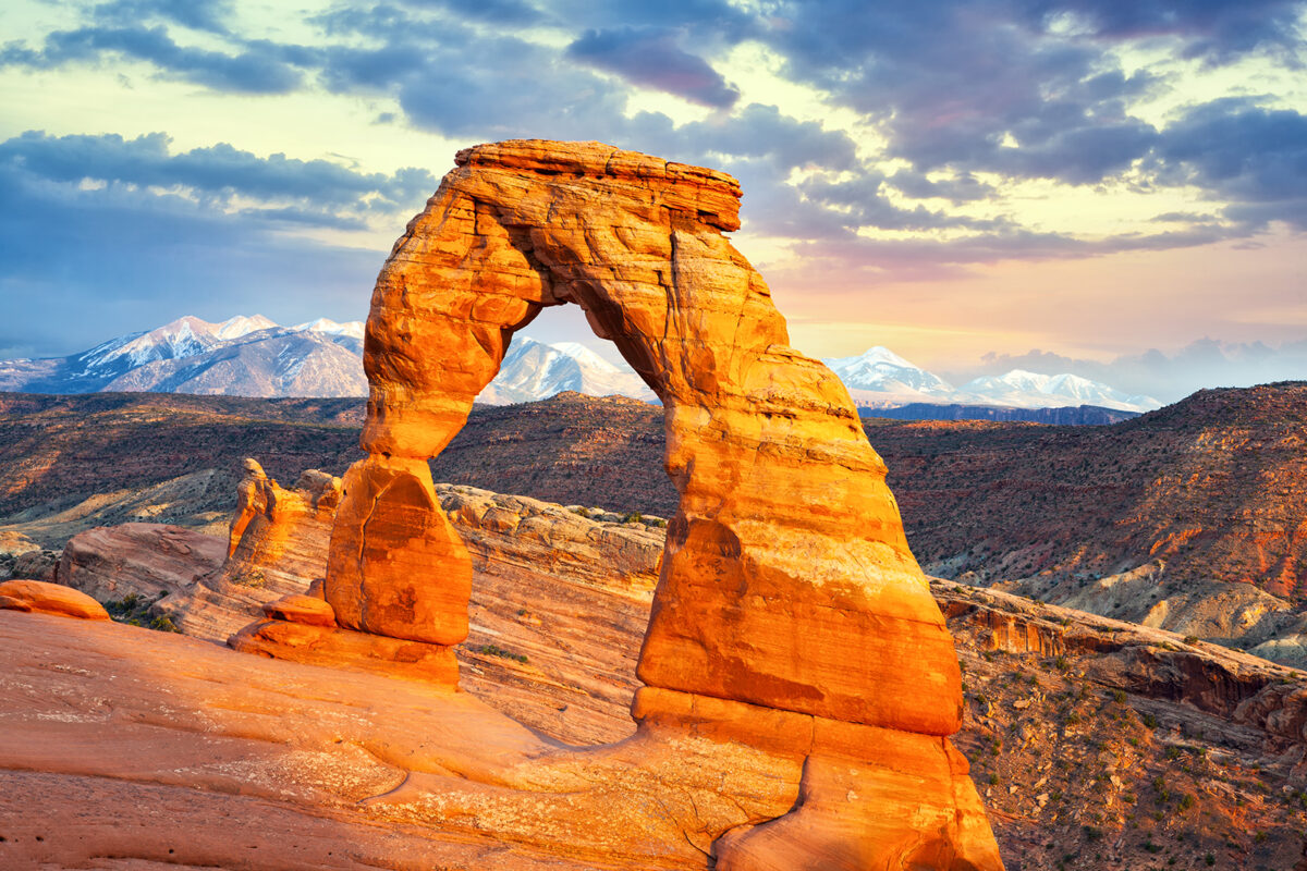 Photo pf Delicate Arch with a view of the La Sal Mountains in the background.