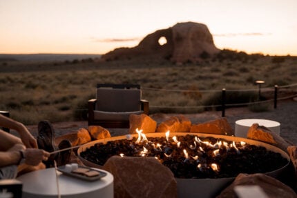 Guests toast complementary marshmallows overlooking Looking Glass Arch at ULUM Moab.