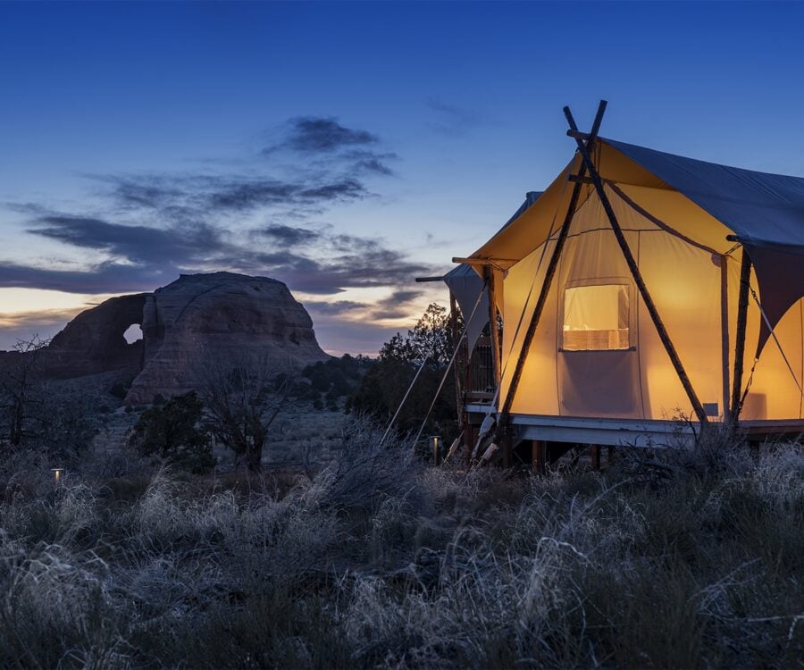 Tent at night with looking glass arch in the background.
