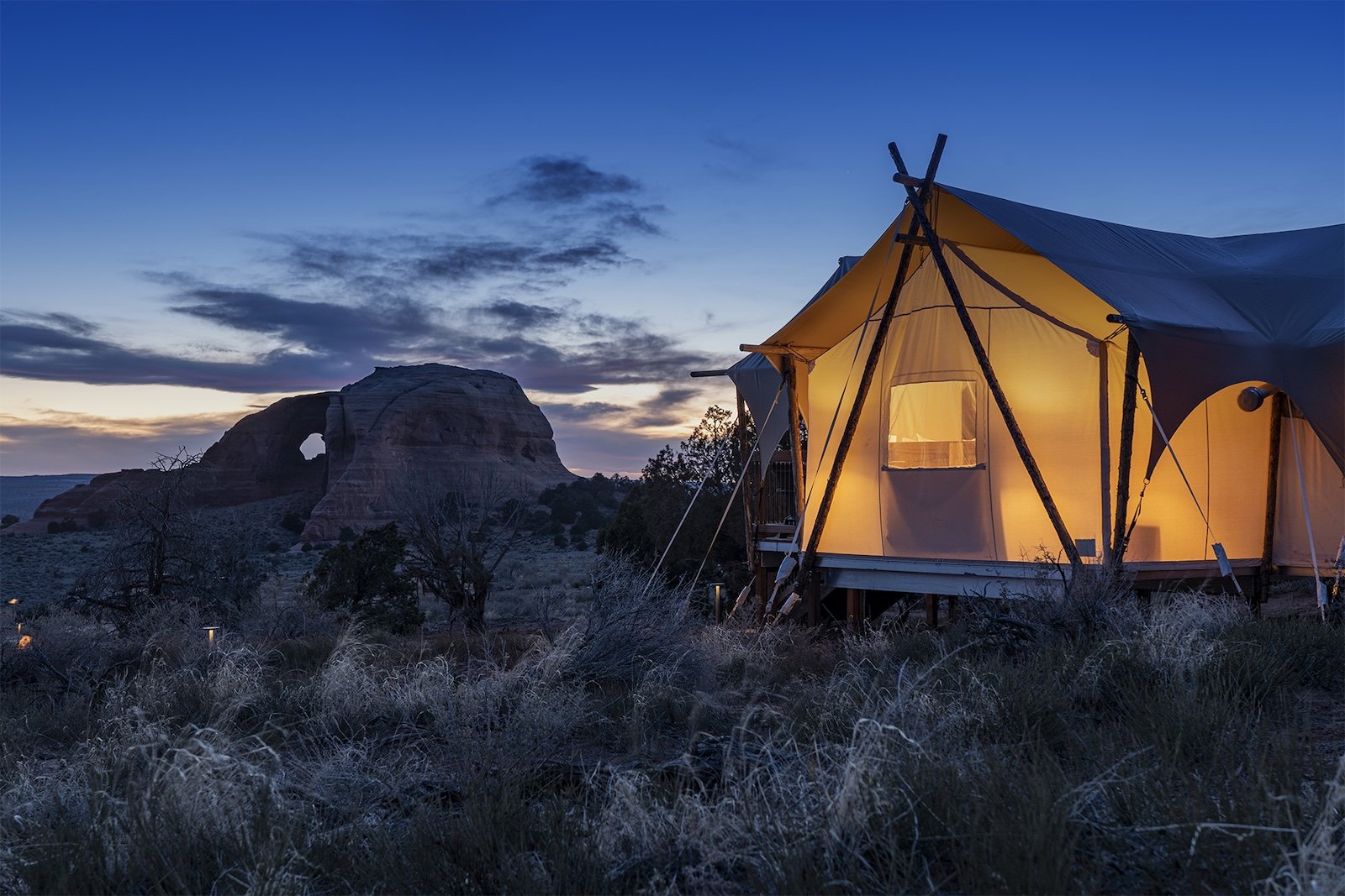 Tent at night with looking glass arch in the background.