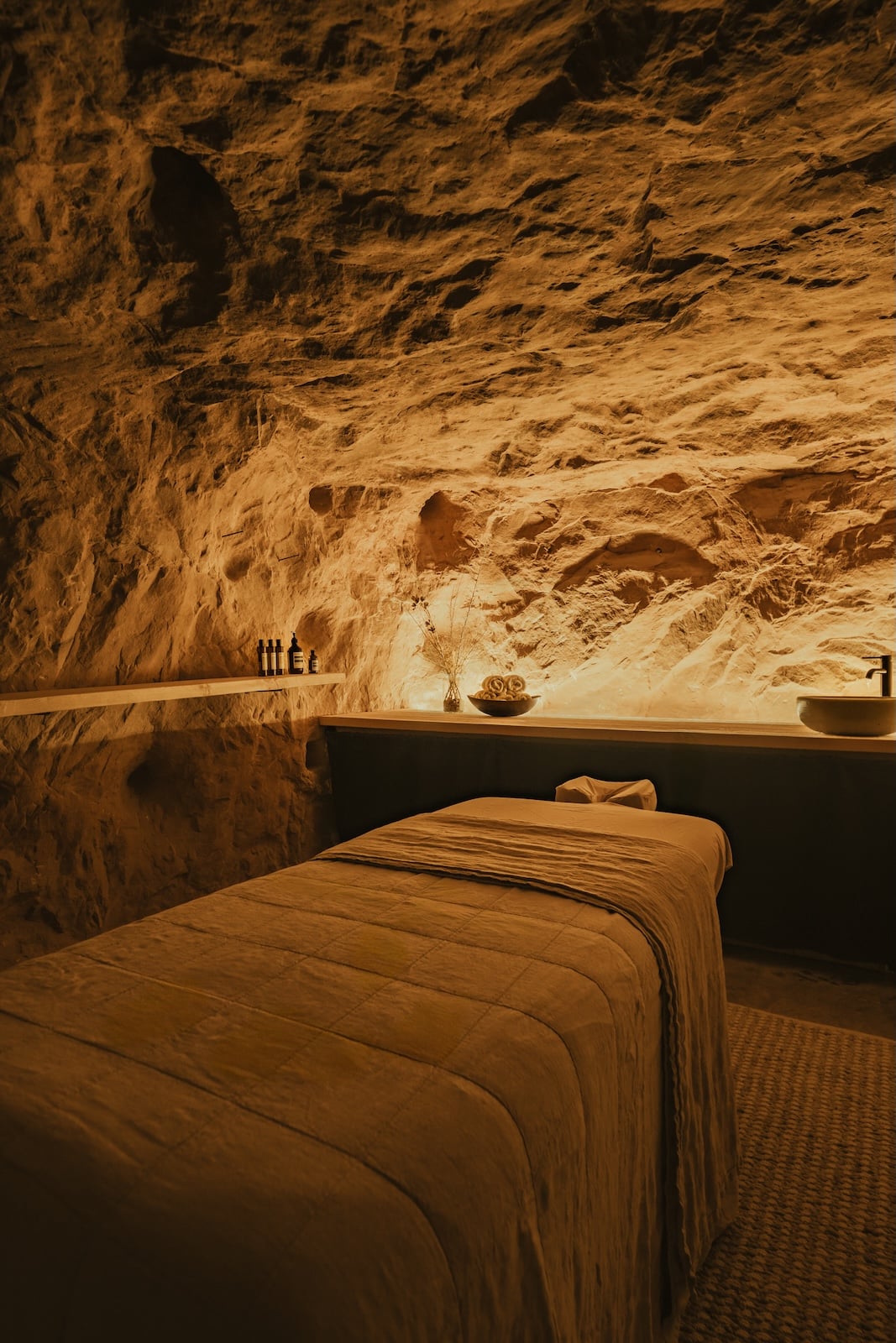 a massage table in a spa with a sink and bowl