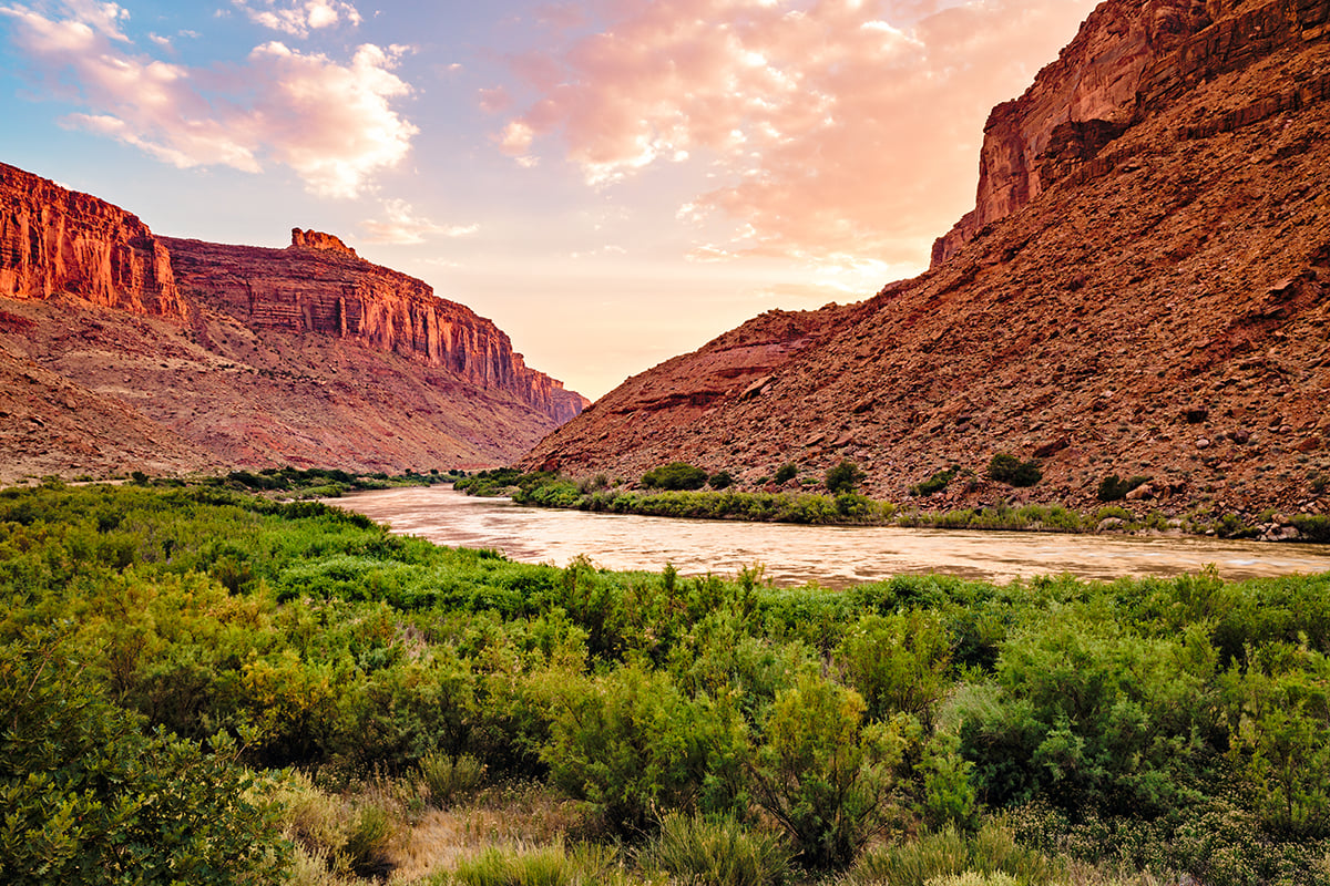 a wide shot of a river running through a canyon with rocky cliffs on either side