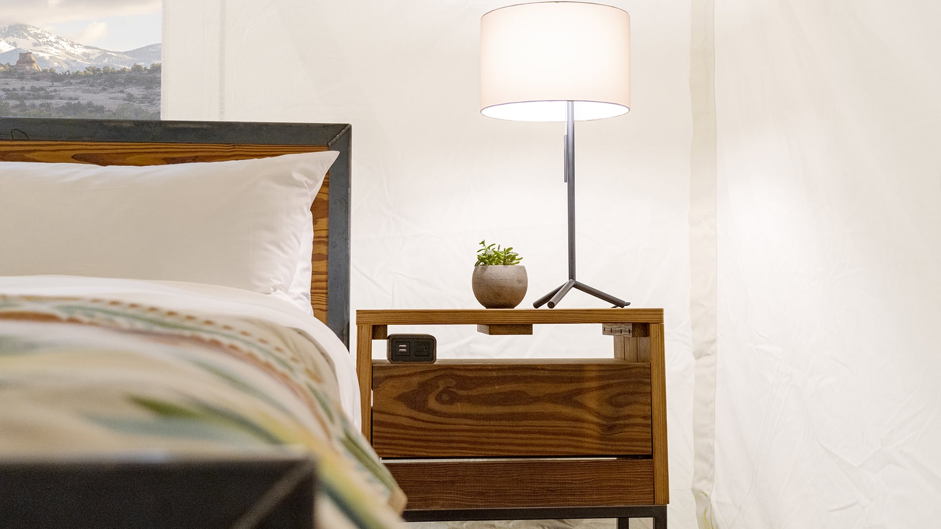 a bed with a wooden headboard and a nightstand with a lamp