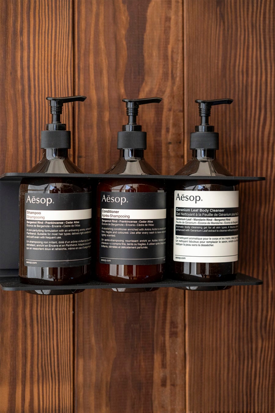 Three bottles of Aesop products on a shelf