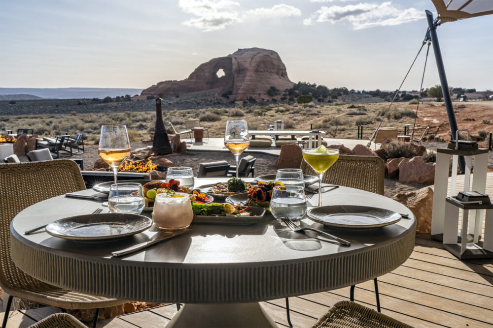 A dining setting at ULUM Moab with views of Looking Glass Rock.