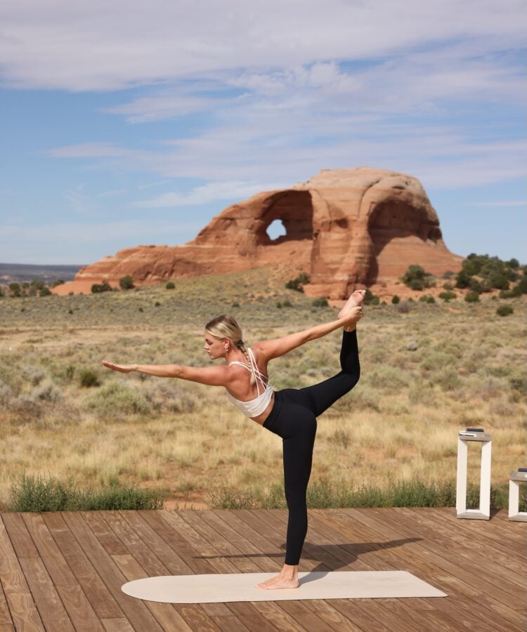 Woman doing yoga in front of Looking Glass arch.