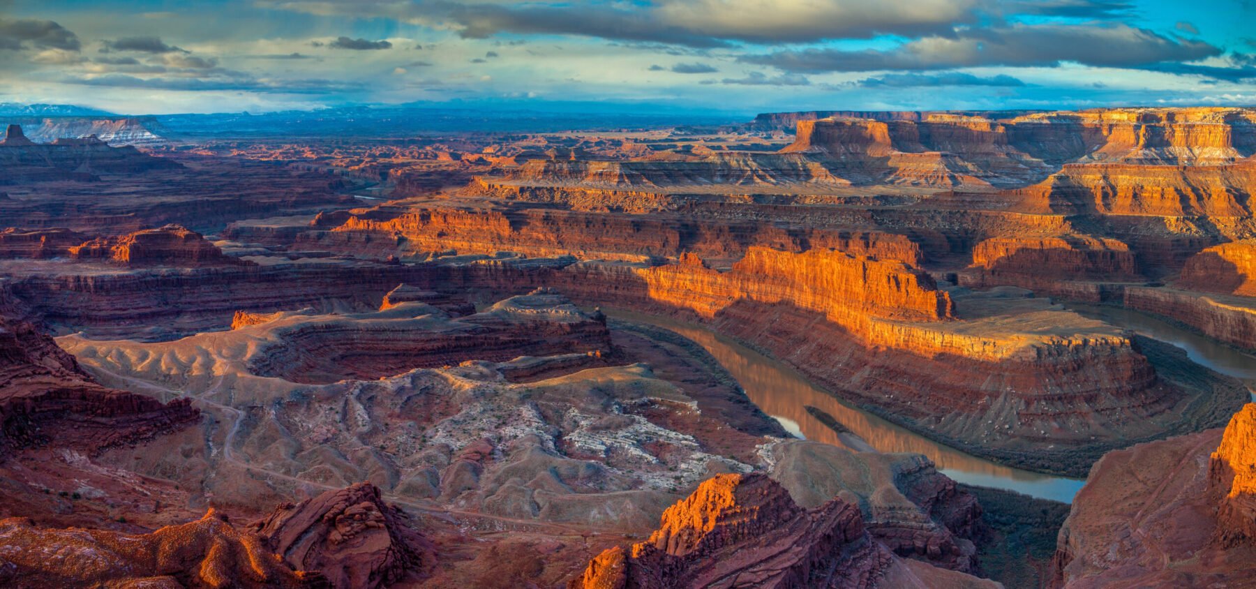 A sweeping overview of Dead Horse State Park from Dead Horse Point Overlook, showing a bend in the Colorado River.